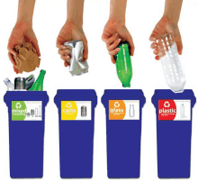 a person is putting a bottle into a recycling bin