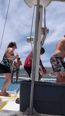 a group of people on a boat including a man in a red shirt and a woman in a floral top