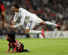 a soccer player with the number 7 on his jersey is flying over a player with the number 9 on his jersey