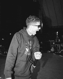 a man singing into a microphone wearing a sweatshirt that says ' myth ' on it