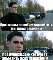 a man in a black suit stands in front of a row of cars in a park