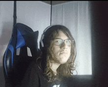 a man with long hair and glasses is wearing headphones and a black shirt