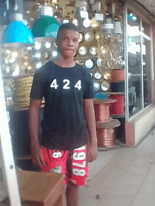 a young man wearing a black shirt that says ' 424 ' on it