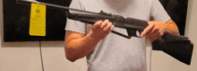 a man holding a rifle with a tag that says ' ruger ' on it