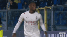 a soccer player wearing an emirates fly better jersey celebrates