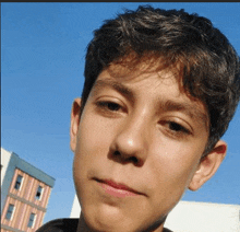 a young boy is taking a selfie in front of a building .