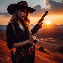 a woman in a cowboy hat holds a gun in front of a sunset