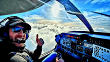 a man giving a thumbs up while sitting in a cockpit of an airplane