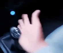 a person is holding a can of soda in their hand in a car .