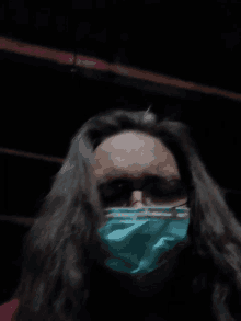 a woman with long hair is wearing a green mask