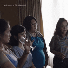 a group of women are standing in front of a window with the words la guarimba film festival on the bottom