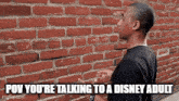 a man is standing in front of a brick wall with the caption " pov you 're talking to a disney adult " .