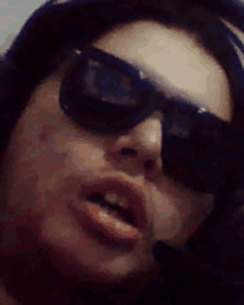 a close up of a woman wearing sunglasses and a headset