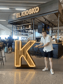 a man stands in front of a sign that says el kiosko on it