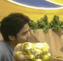 a man is holding a bowl of gold balls in front of him .