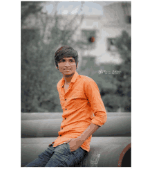 a young man in an orange shirt is leaning against a pipe with a photo taken by praveen siddhant