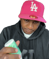 a man wearing a pink la hat holds a bottle in his hand