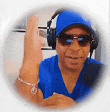 a man wearing headphones and sunglasses is giving a high five