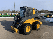 a yellow and black john deere tractor is parked in the snow