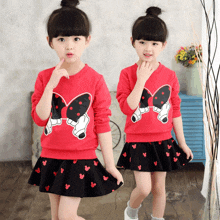 two little girls wearing matching outfits with minnie mouse on them