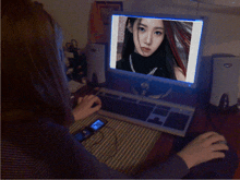 a woman sits at a desk with a dell computer