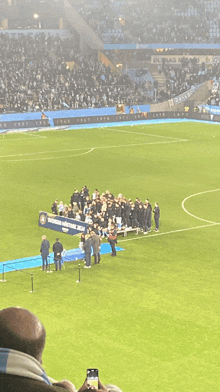 a group of people standing on a soccer field with a banner that says champions league on it