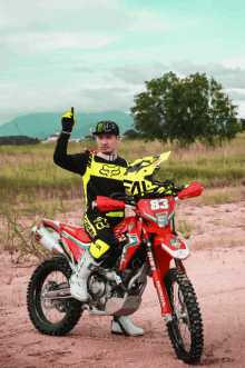 a man riding a red dirt bike with the number 83 on the front