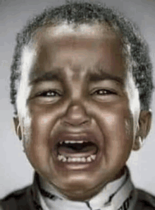 a young boy is crying with his mouth open and tears running down his face .