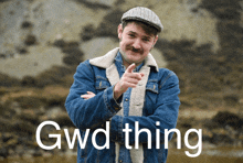 a man in a denim jacket and hat is pointing at the camera with gwd thing written on the bottom