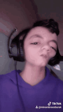 a young boy wearing headphones and a purple shirt has a tiktok account