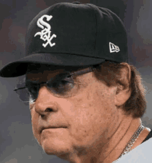 a man wearing a white sox baseball cap and glasses