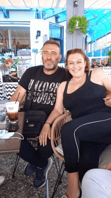 a man and a woman sit at a table with a man wearing a black shirt that says unlock your soul