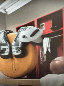 a football is sitting on a shelf in a locker room next to a helmet and pads