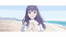 a girl with purple hair and green eyes is standing on a beach with her hands folded .