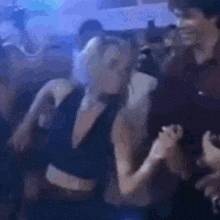 a man and a woman are dancing in a nightclub .