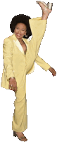 a woman in a yellow suit is standing with her leg up