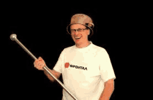 a man wearing a helmet and glasses is holding a cane in his hand .