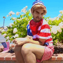 a man in an american flag outfit is sitting on a wall