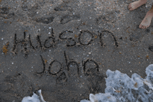 the name hudson john is written in the sand