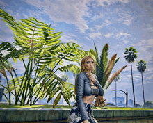 a woman in a crop top stands in front of a palm tree