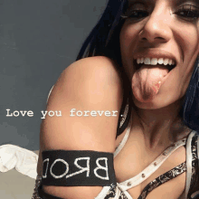 a woman sticking her tongue out with the words love you forever written on her arm