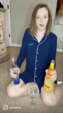 a woman is sitting on the floor holding two bottles of soda