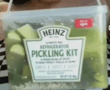 a bucket of heinz refrigerator pickling kit filled with green pickles .