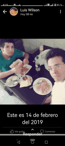 two men sitting at a table with plates of food in front of them and the date 14 de febrero del 2019