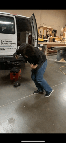 a man is dancing in front of a van that says the custom camper company