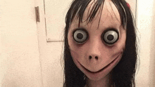 a close up of a person wearing a scary mask with big eyes and a smile on their face .