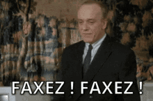 a man in a suit and tie is saying " faxez ! faxez ! "