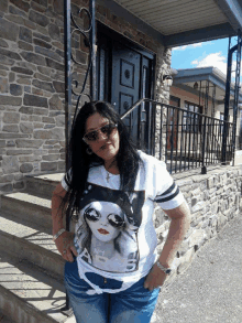 a woman standing in front of a stone building wearing a shirt that says no 1