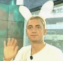 a man wearing bunny ears on his head is waving .