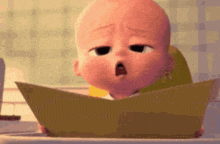 a baby from the boss baby is reading a book while sitting in a chair .